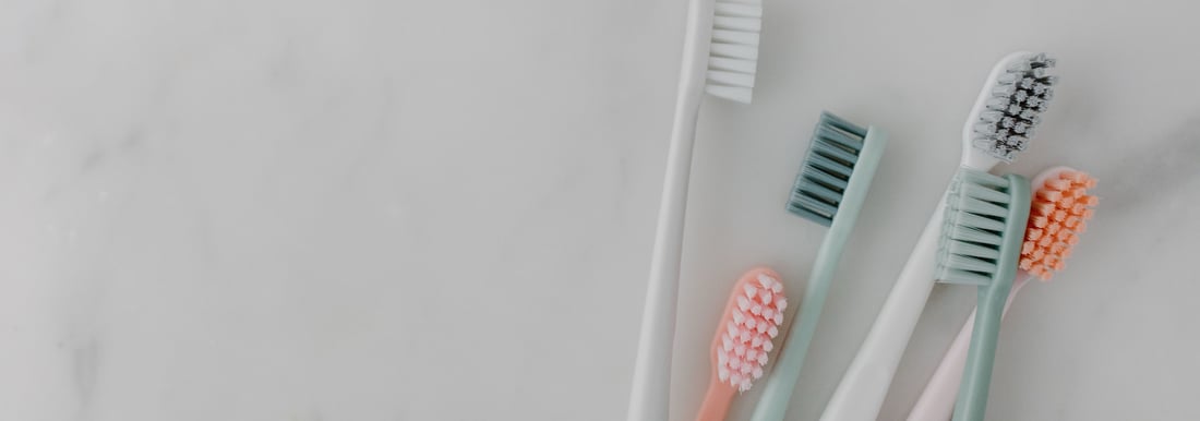 Colourful toothbrushes arranged on a marble surface