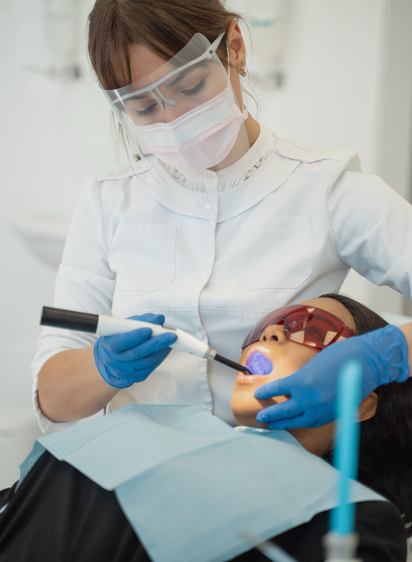Dentist curing a tooth restoration with a chairside curing light