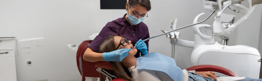 Dental hygienist placing a tooth-coloured filling for a patient in a Welland treatment room