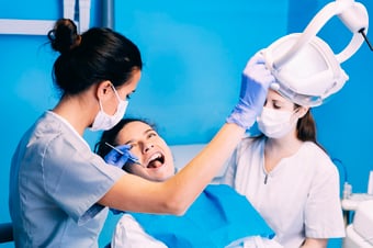 Dentist repairing a patient's chipped tooth in the treatment chair
