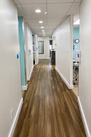 Bright clinic corridor leading to treatment rooms at Welland Dental Centre