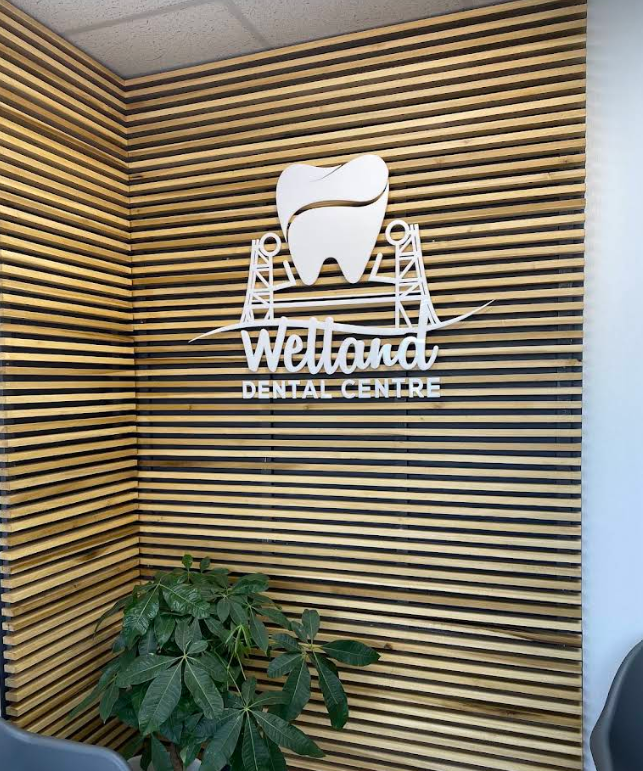Welland Dental Centre logo on a wooden slat feature wall