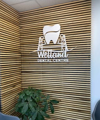 Welland Dental Centre logo on a wooden slat feature wall